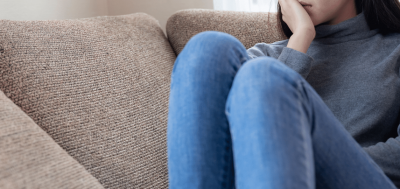 Information A girl sitting on a couch with her hand to her face