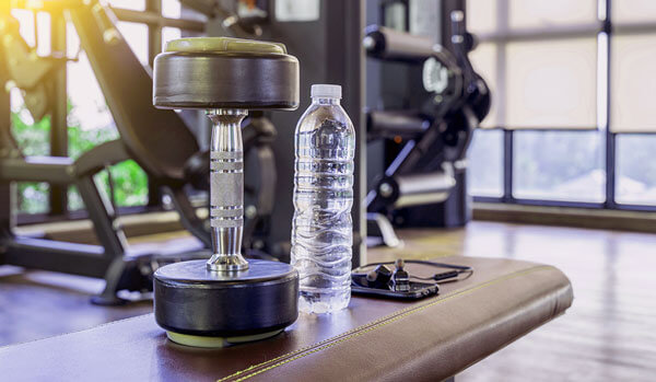 Dumbbell and bottle of water in fitness club