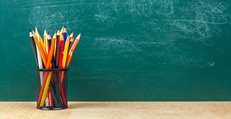 coloured pencils in front of blackboard
