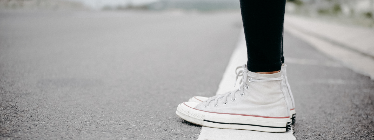 picture of a person wearing converse runners standing on a white painted line
