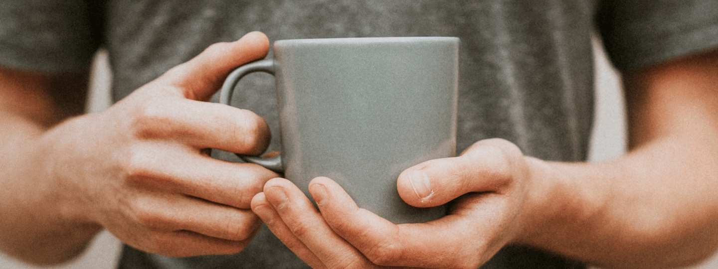 School leadership Self-care A image of a man holding a grey cup