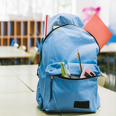 school rucksack with pencil case items hanging out
