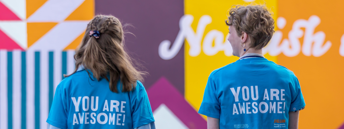2 young people wearing you are awesome tshirts from behind close up