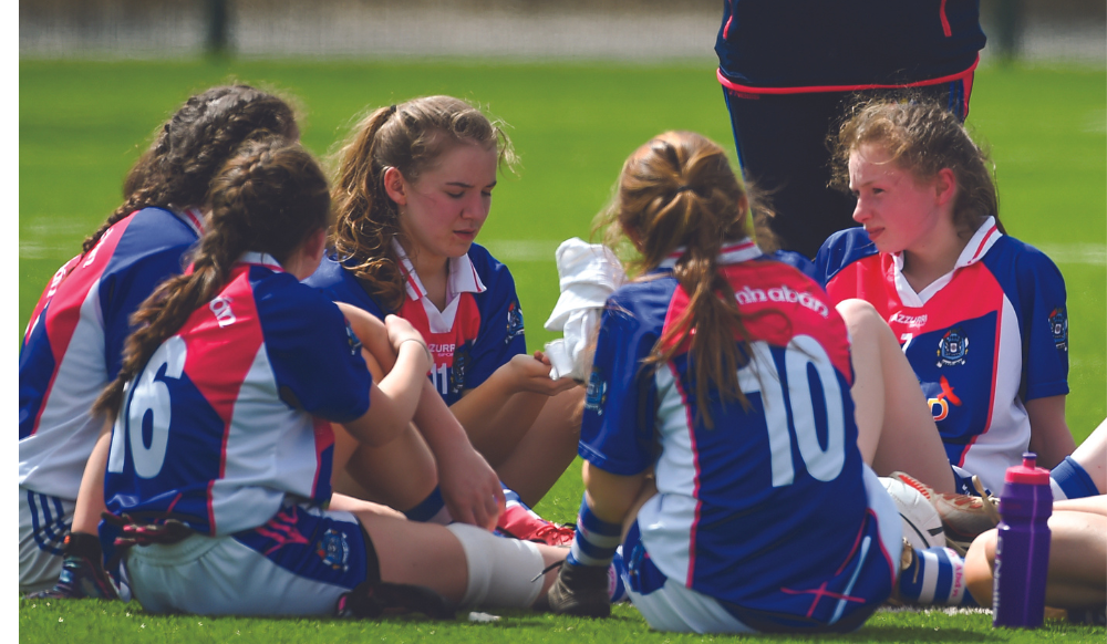 LGFA young players sitting on ground